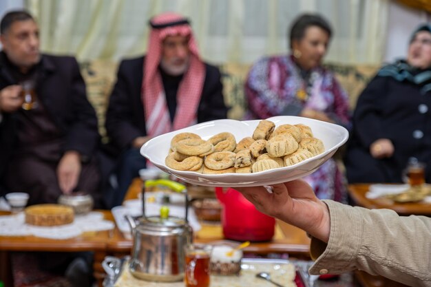 Handhoudende Eid snoepjes te midden van een familie bijeenkomst Beteken warmte gastvrijheid en een gastvrije sfeer voor onze gewaardeerde gasten