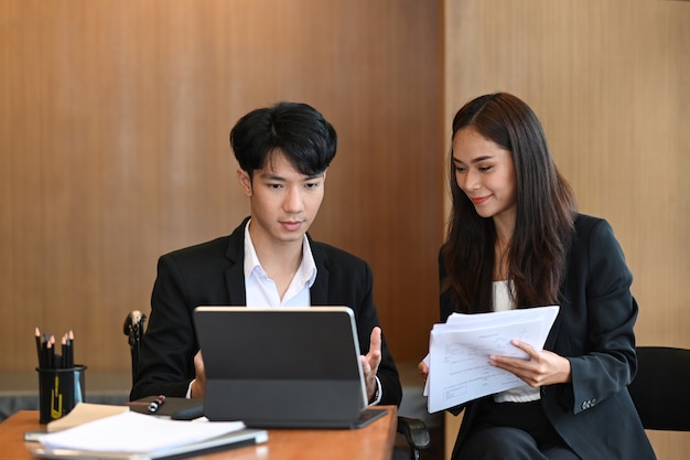 Handicapped businessman in wheelchair working with colleagues in modern office.