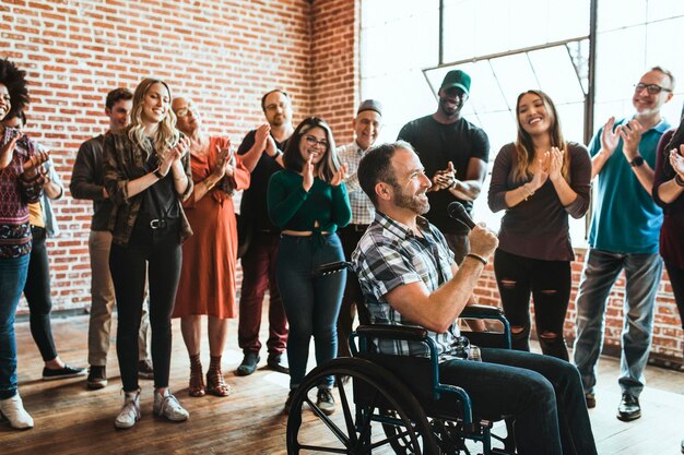 Handicapped man speaking on a microphone in a workshop