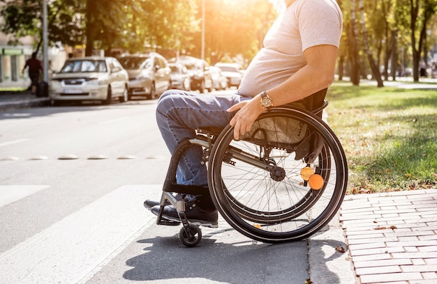 Handicapped man in wheelchair crossing street road.