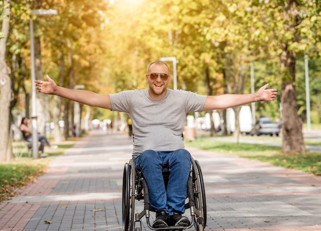 Handicapped man in wheelchair walk at the park alley