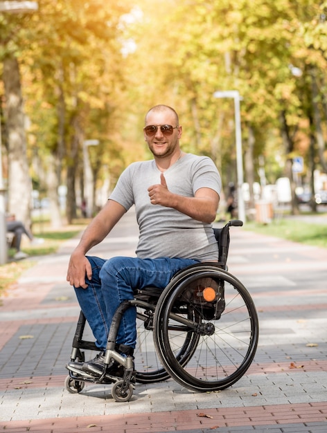 Handicapped man in wheelchair walk at the park alley