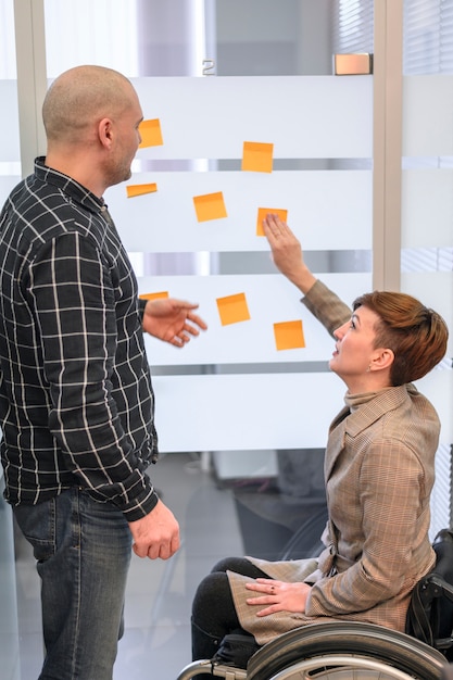 Handicapped woman in office using post-it notes