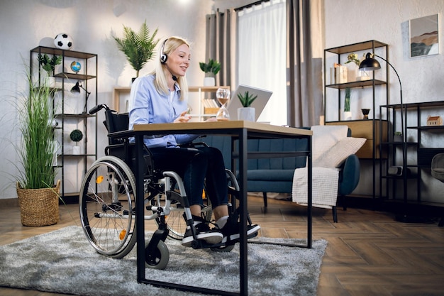 Женщина-инвалид использует гарнитуру и ноутбук для видеозвонка