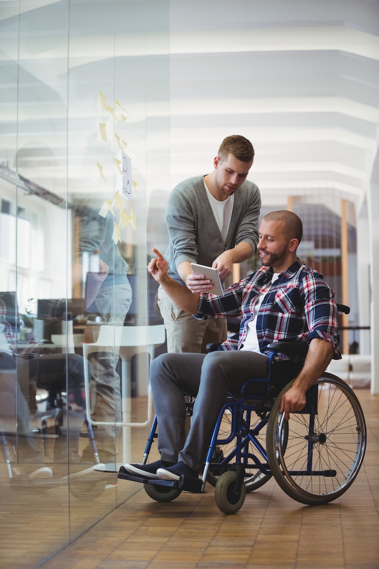 Foto handicapzakenman die met collega op kantoor bespreken