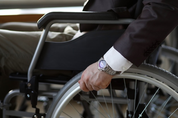 Handicapzakenman met rolstoel tegen bedrijfsbureau