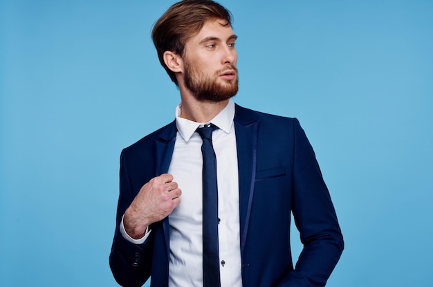 Handige man in pak zelfvertrouwen officiële blauwe achtergrond foto van hoge kwaliteit