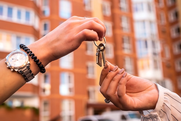 Consegna delle chiavi di casa tra agente immobiliare e nuovo proprietario. concetto di vendita