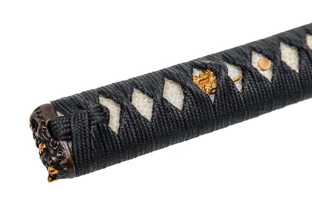 Photo handle of japanese sword wrapped by black silk cord with gold fitting isolated on white