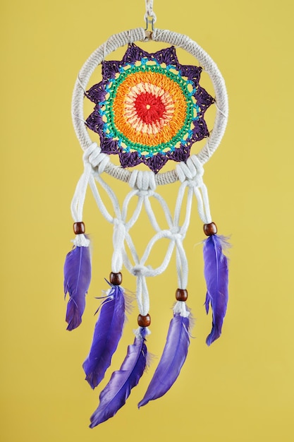 Handmade amulet dream catcher on a yellow