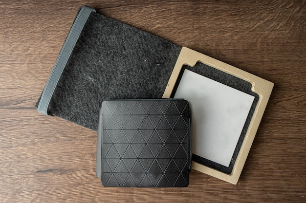 Handmade black wallet made of genuine leather on a wooden background Closeup top view