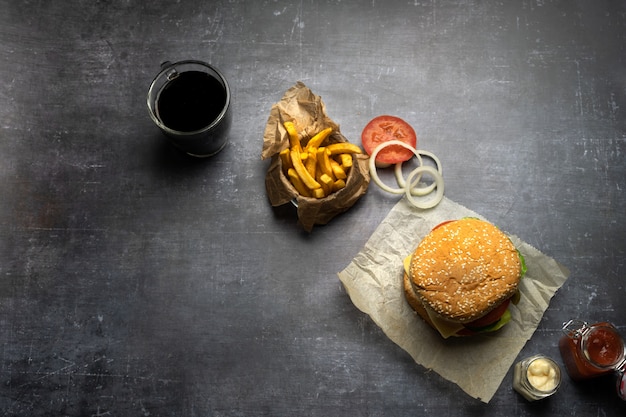 Handmade burger with fries and onion rings and coke