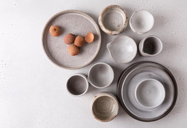 Handmade ceramic tableware, empty craft ceramic on a light\
background. clay plates and cups