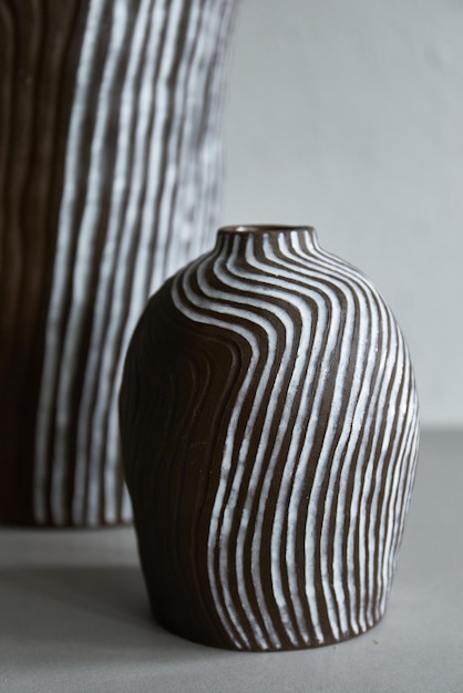 handmade ceramic vase standing on grey table on light background. art of clay. the process of creating pottery