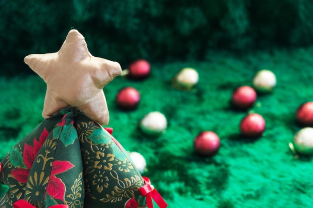 手作りのぽっちゃりクリスマス ツリーの装飾と緑の背景をぼかした写真の生地で作られました。