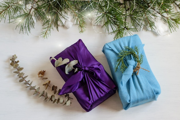 Handmade christmas gift boxes wrapped in textile cloth in japanese traditional furoshiki style.