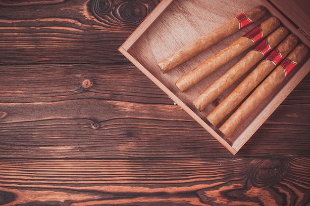 Handmade cigars on a wooden background with copyspace