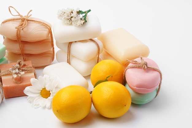 手作りの柑橘類の石鹸と白い背景の上の新鮮な果物