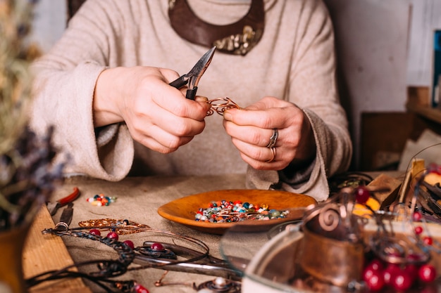 Handmade copper wire working tools on the table with accessoires. handicraft people art concept