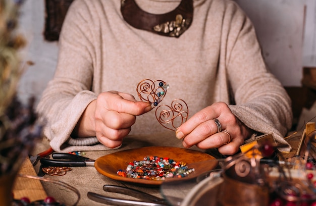 Foto utensili da lavoro fatti a mano con filo di rame sul tavolo con accessori. concetto di arte della gente dell'artigianato