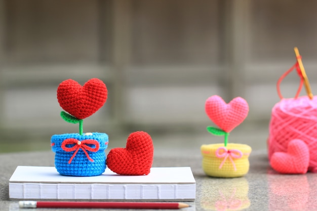 handmade crochet heart with a hook and a ball of yarn