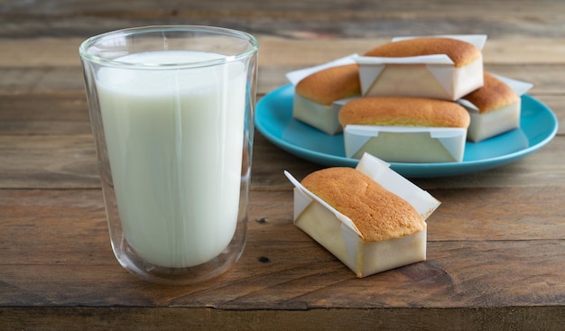 Handmade cupcake and glass of milk on a wooden background. Copy space. Handmade traditional Spanish "Mantecadas".