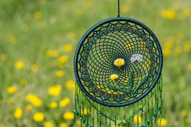 Handmade dreamcatcher in a field full of flowers