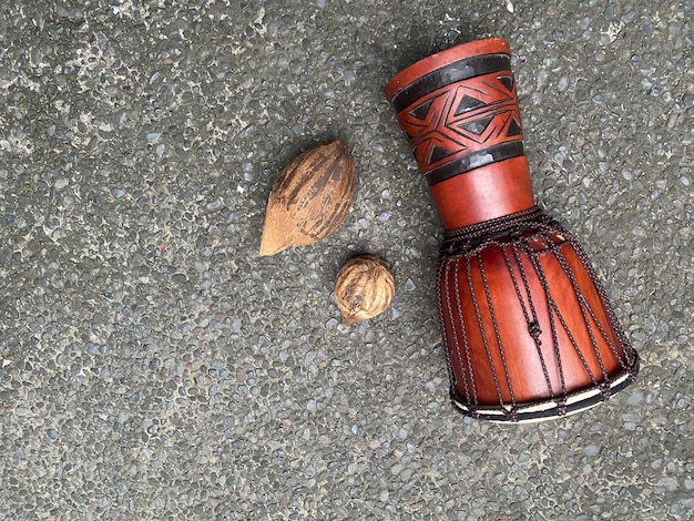 A handmade drum and nuts on the ground