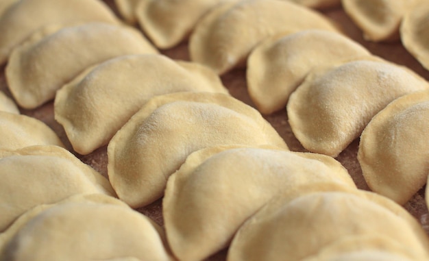 handmade dumplings on a shelf in rows for freezing