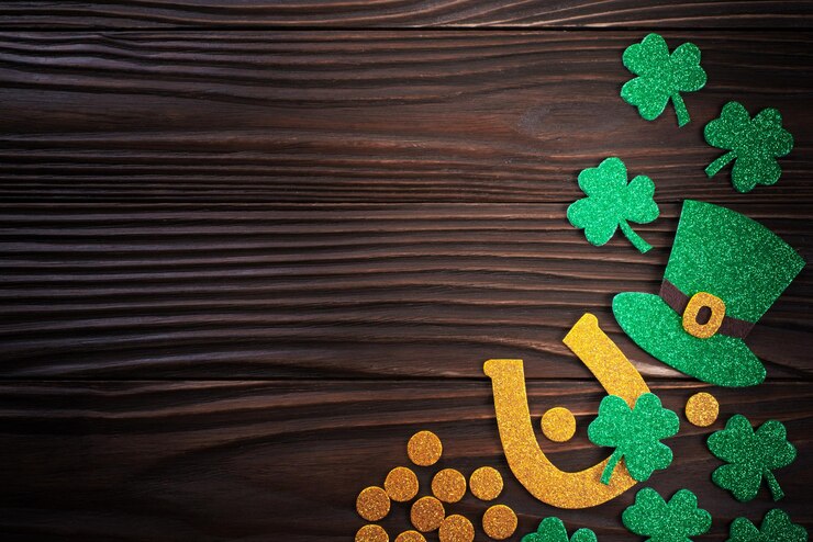 Photo handmade felt threeleaved shamrock horseshoe hat and coins on wooden background