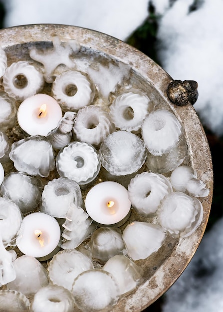 Handmade garden ice decoration in shape of mini bundt, Christmas trees, snowman with candels