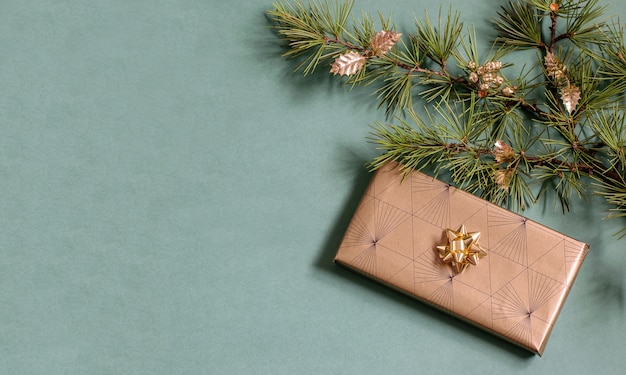 きらめく環境にやさしい紙に包まれた手作りのギフトボックス、輝くつまらないものが付いたクリスマスツリーの枝。