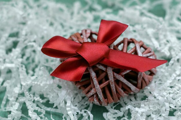 Foto forma di cuore fatta a mano con un arco scarlatto brillante concetto di regalo per i cari