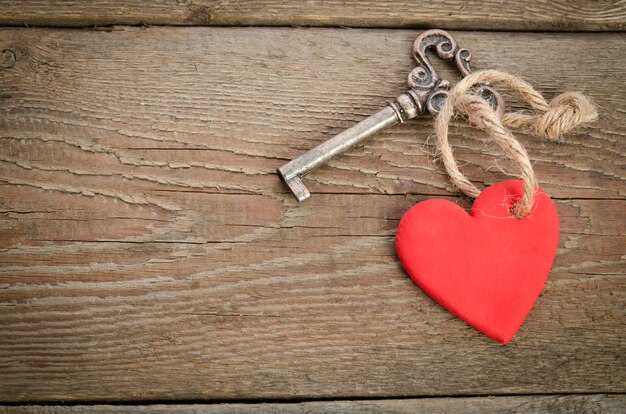 Handmade Heart with key together lying on a wooden board. Top view