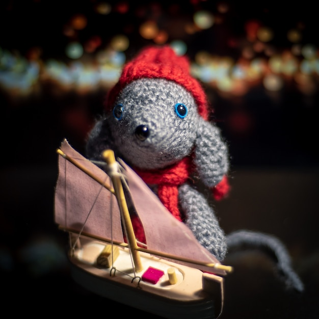 Handmade knitted toy. Amigurumi rat toy. Crochet stuffed animals. The mouse is crocheted with the ship.