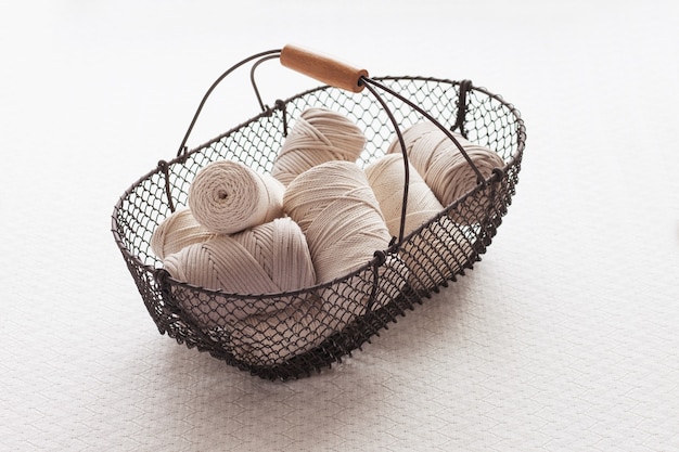 Handmade macrame braiding and cotton threads in basket