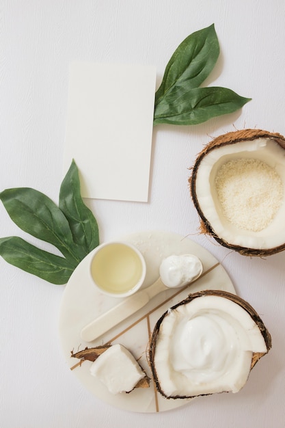 Handmade natural body scrub made with coconut and blank card on white backdrop