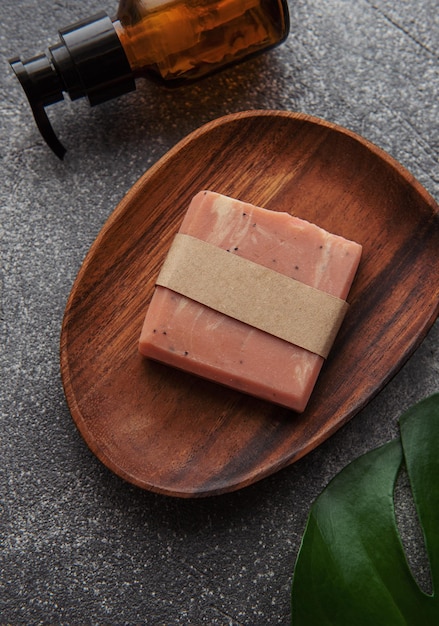 Photo handmade natural soap bar massage oil and green leaf on a concrete background