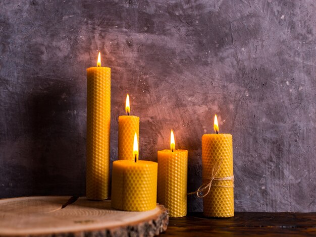a handmade of natural wax with texture of honeycomb bees candles burns on the table, an unusual element of the interior.