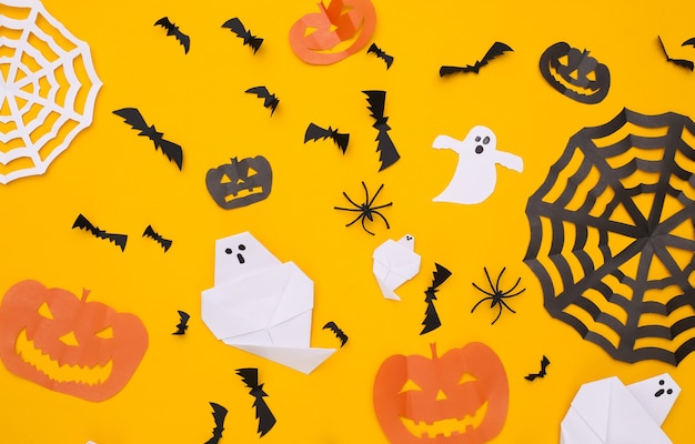 Handmade paper cut Halloween decor on yellow background. Halloween background. Top view. Flat lay