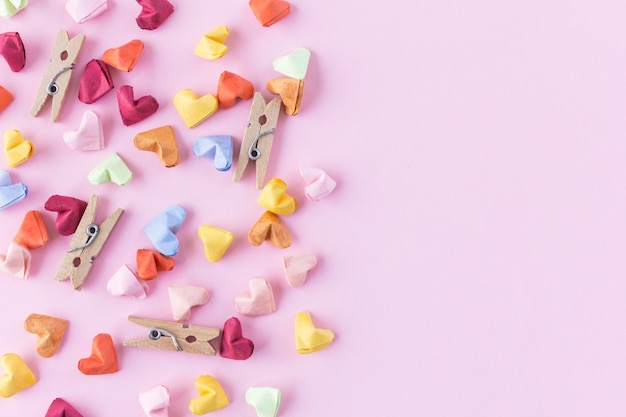 Handmade paper heart on pink background in top view