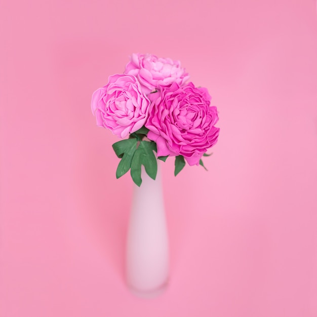 Peonie fatte a mano in vaso su sfondo rosa