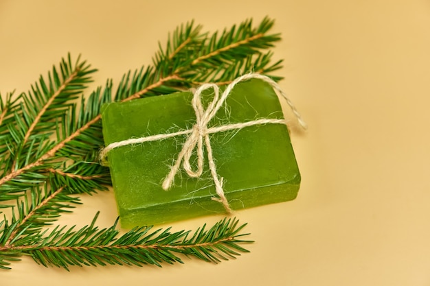 Handmade pine Soap with needles branches on a beige surface