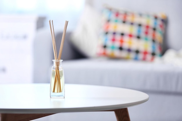 Handmade reed freshener on white table in living room close up