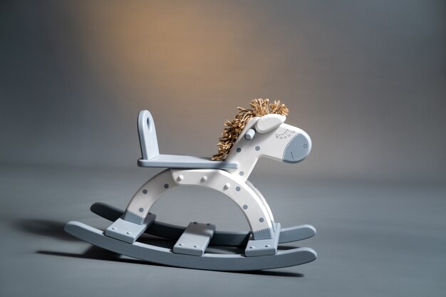 Handmade rocking horse on a gray background.