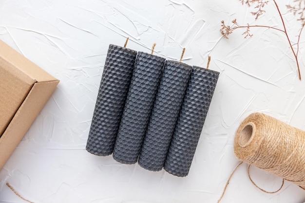 Handmade rolled beeswax candles craft box and jute rope Putty white background Holiday present Eco gift Flat lay top view