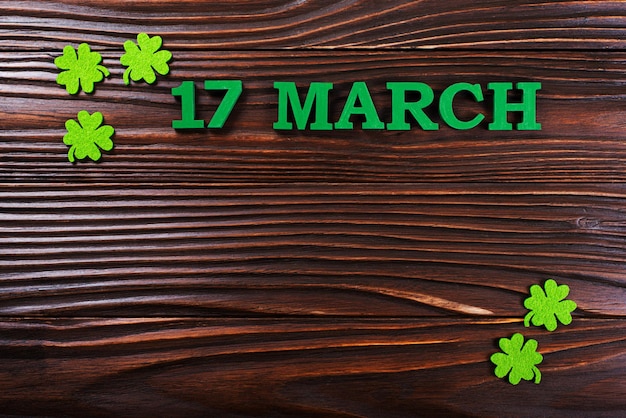 Handmade Shamrock leaves on dark wooden background with copyspace flat lay view