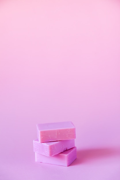 Handmade soap bars on soft pink background.