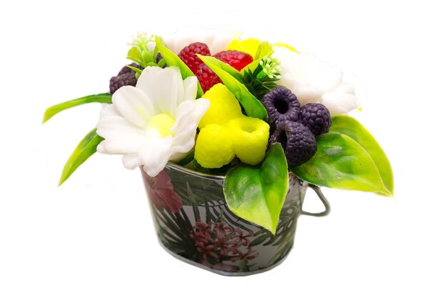 Photo handmade soap form of daisies and berries in a metal minibucket on a white background