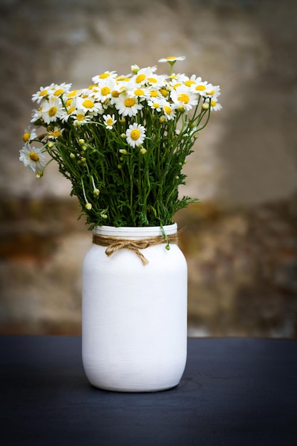 テーブルの上に野生の花が飾られた手作りの花瓶